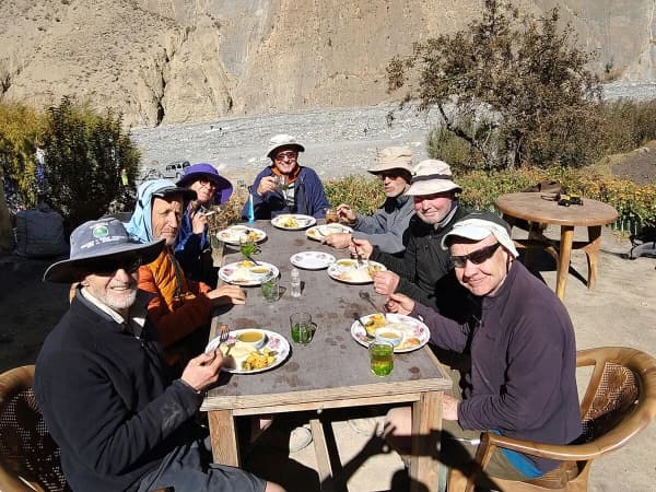 Group Of Trekkers Resting At Teahouse Having Lunch And Having Stories